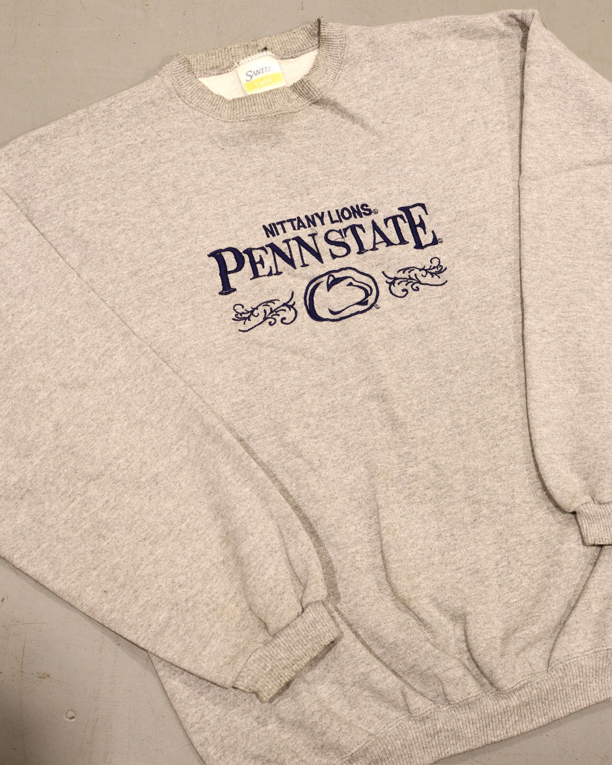 Vintage heather gray Penn State crewneck sweatshirt with navy collegiate lettering and ribbed cuffs