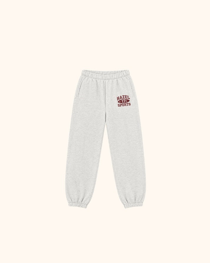 Light gray jogger pants with elastic waistband and cuffs and a red sports logo