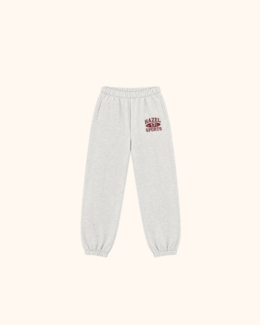 Light gray jogger pants with elastic waistband and cuffs and a red sports logo
