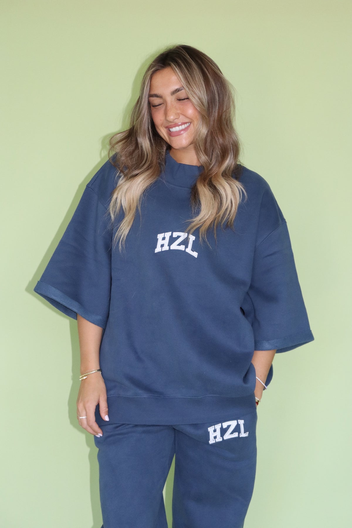 Woman wearing a navy HZL short sleeve mockneck top with matching pants