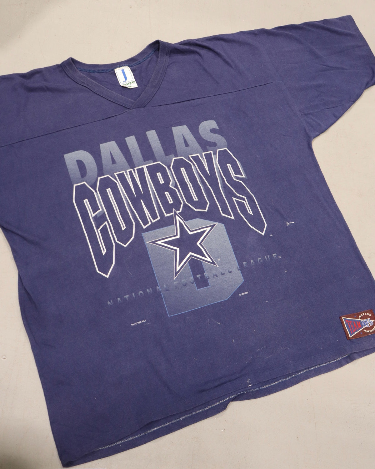 Purple Dallas Cowboys graphic tee with bold layered lettering and star logo on the front