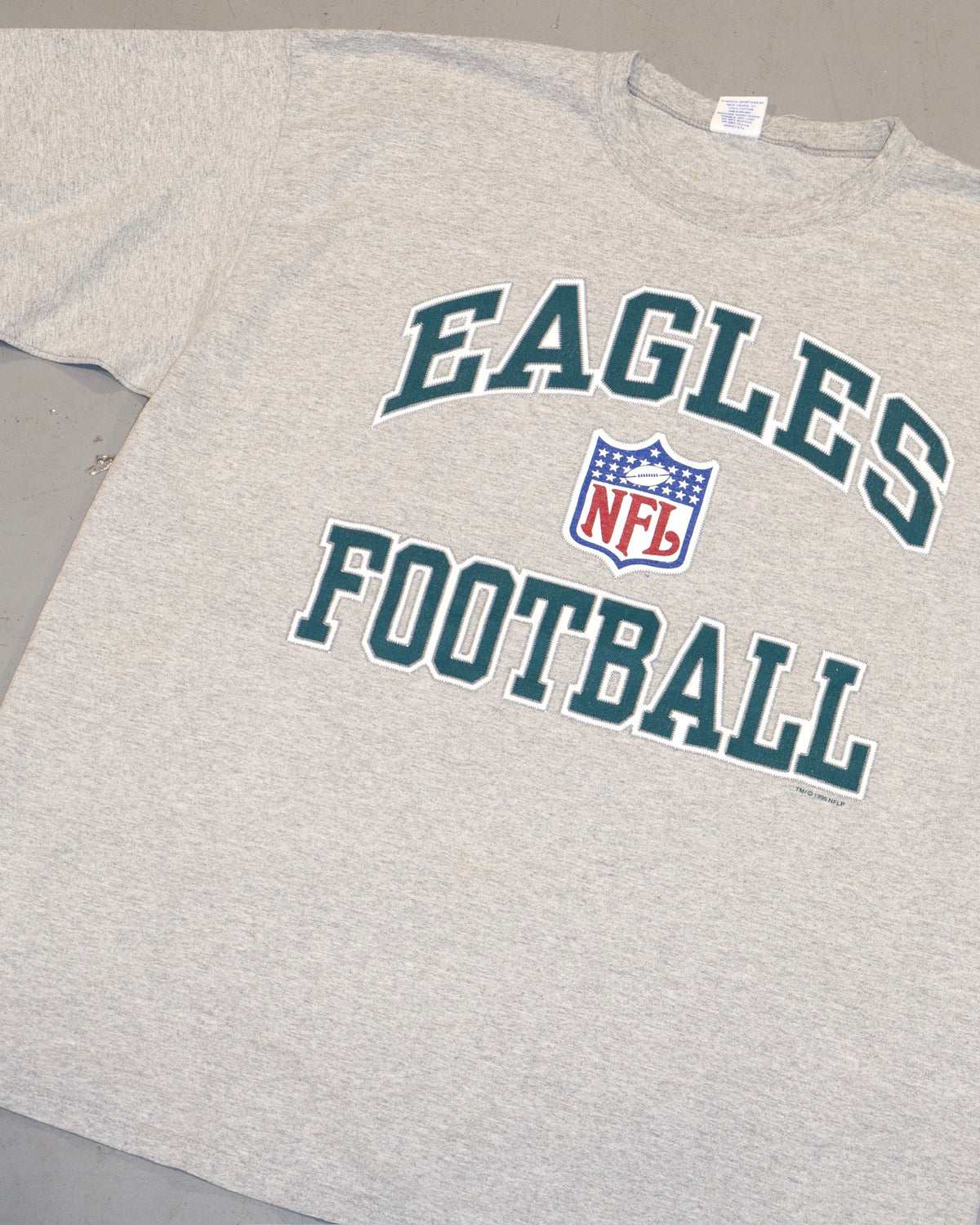 Gray vintage Eagles football tee with teal lettering and an NFL shield graphic