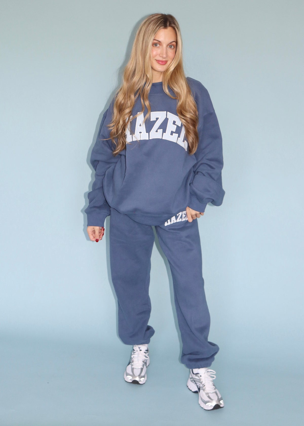 Model wearing a blue Hazel mockneck sweatshirt with matching jogger pants and sneakers