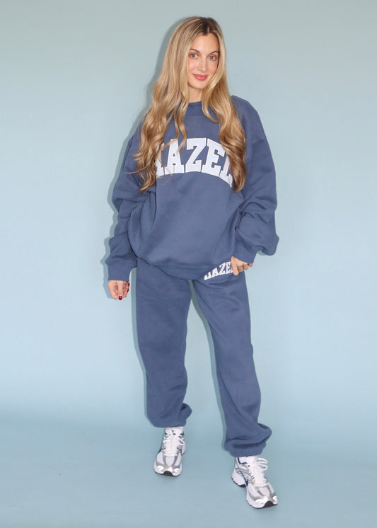 Model wearing a blue Hazel mockneck sweatshirt with matching jogger pants and sneakers