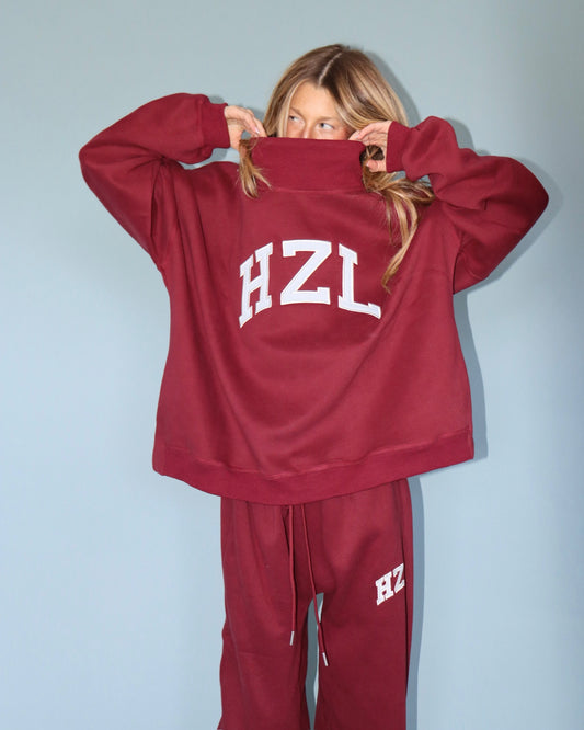 Model wearing a burgundy HZL high neck sweatshirt with matching drawstring sweatpants